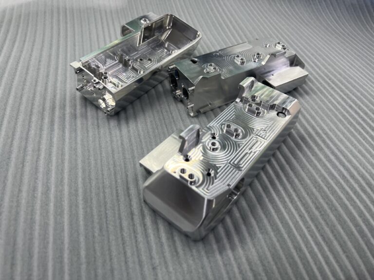 Machined aluminum housings with internal pockets, raised mounting features and drilled holes