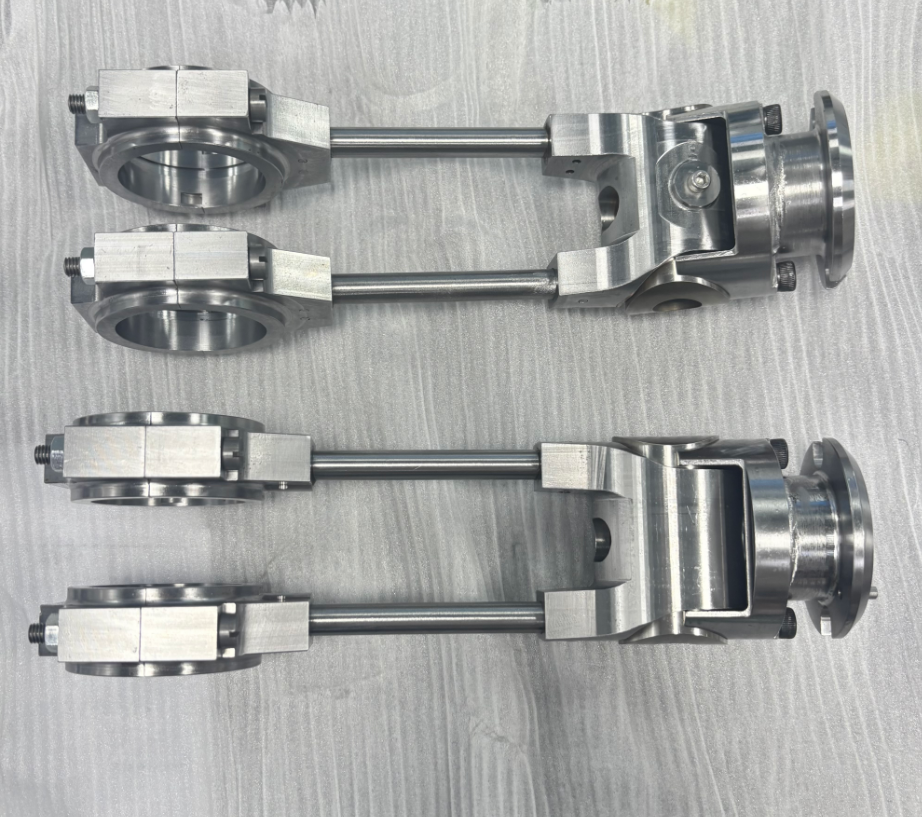 Two custom robot arm linkage assemblies with clamping blocks and mounting flanges